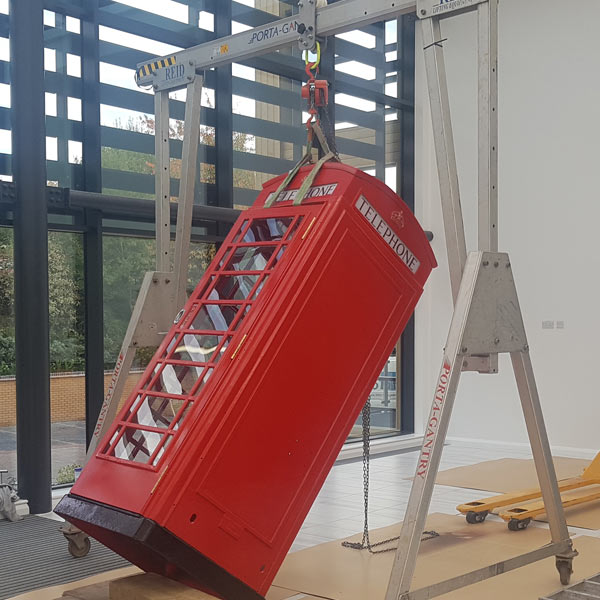 Converted telephone box being moved and lifted at slimming world HQ