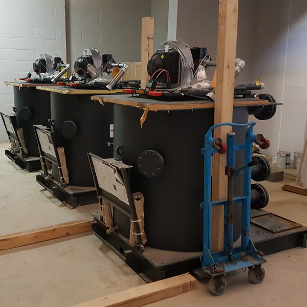 Sectional boiler components being moved into a school plant room